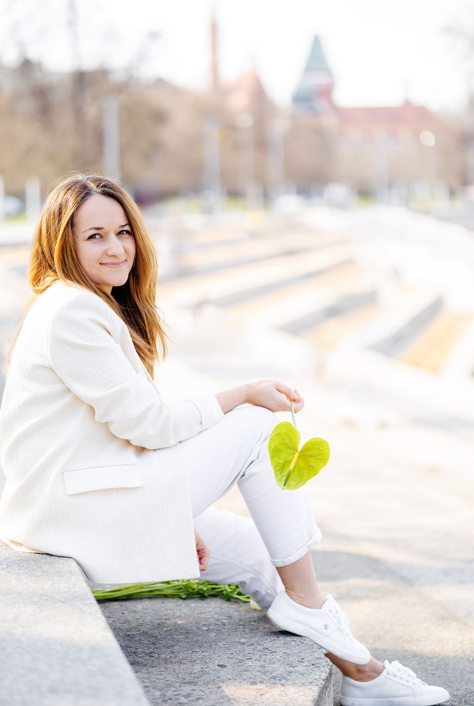 Właścicielka Svala Decor w białym stroju siedząca na bulwarze